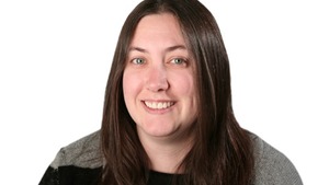 professor wearing a black shirt in front of a white backdrop